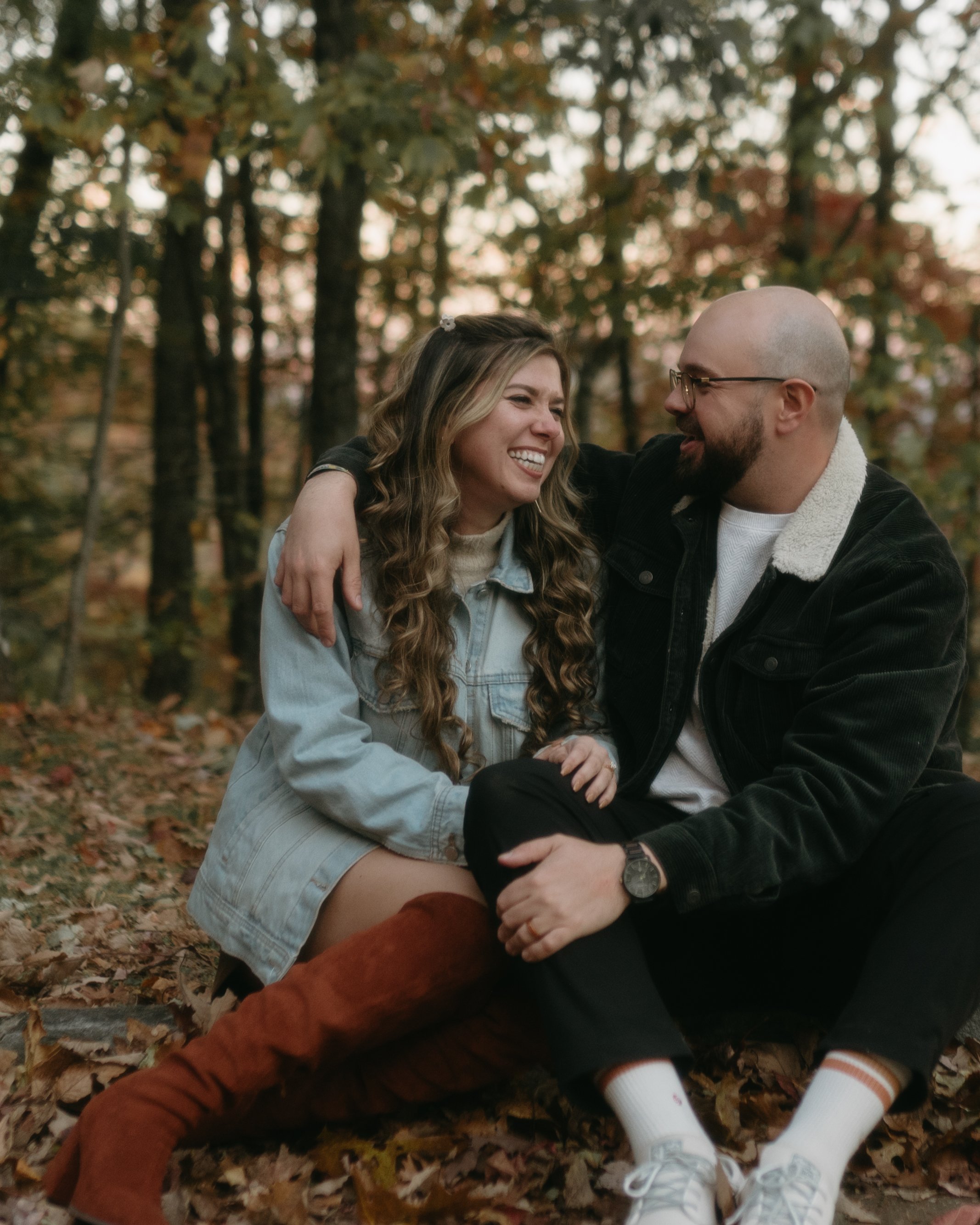 Sitting on the forest floor in a drift of brown leaves, in denim and corduroy, laughing at each other.
